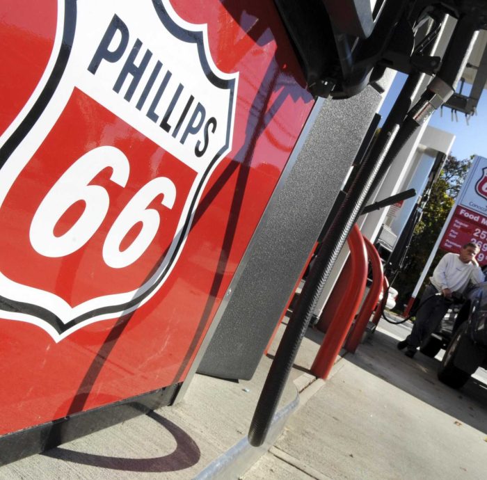FILE - In this Oct. 26, 2009 file photo, a customer fuels up his car at a Phillips 66 gas station in Woburn, Mass. ConocoPhillips is naming its new refining business Phillips 66 _ the name it used on gas stations for decades. The oil company has previously said it will separate the part of its business that includes refining, marketing, and chemicals. On Thursday, Nov. 10, 2011 it said it will name that business Phillips 66 and base it in Houston. (AP Photo/Lisa Poole, File)